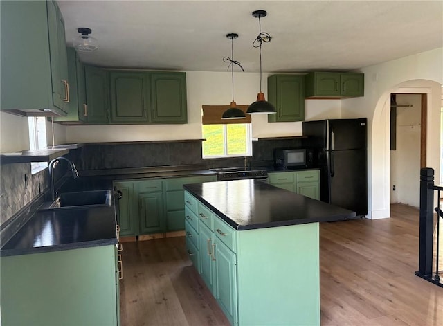 22101 Pleasant Dr, Bernard, IA 52032 - kitchen with green cabinetry, a sink, black appliances, arched walkways, and dark countertops