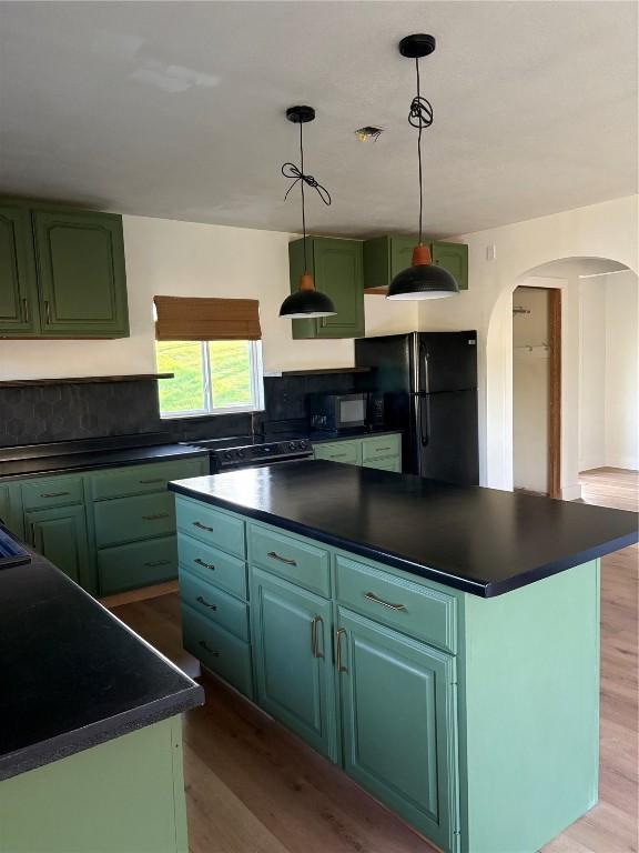 22101 Pleasant Dr, Bernard, IA 52032 - kitchen featuring black appliances, dark countertops, arched walkways, and wood finished floors