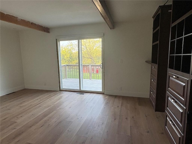 22101 Pleasant Dr, Bernard, IA 52032 - empty room with beamed ceiling, light wood finished floors, and baseboards