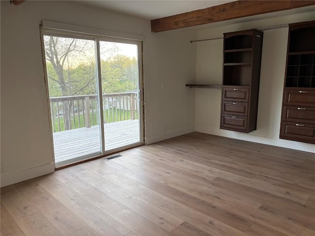 22101 Pleasant Dr, Bernard, IA 52032 - unfurnished bedroom with access to outside, light wood-style flooring, beam ceiling, and baseboards