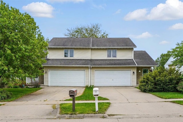 traditional home featuring a garage, a front lawn, and driveway