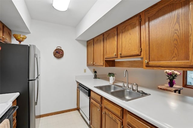 kitchen featuring freestanding refrigerator, white dishwasher, light countertops, and a sink