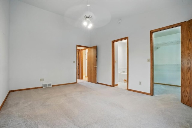unfurnished bedroom with carpet, a closet, visible vents, baseboards, and a spacious closet