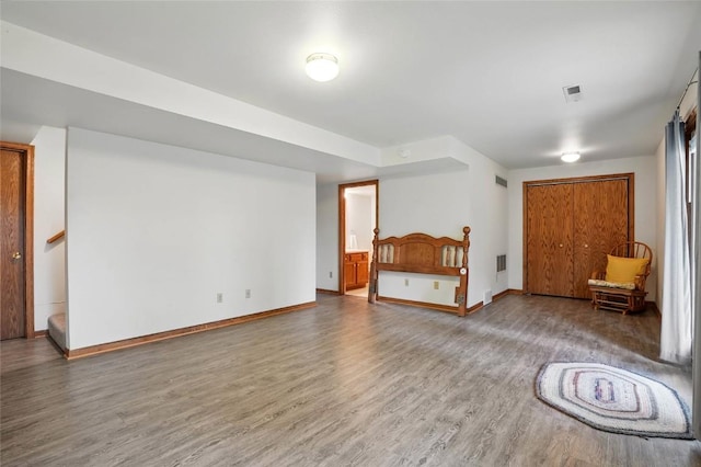 additional living space featuring visible vents, wood finished floors, baseboards, and stairs