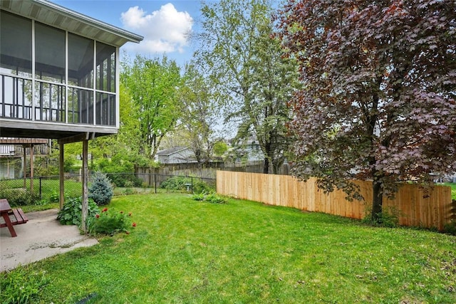 view of yard featuring a sunroom, a patio, and a fenced backyard