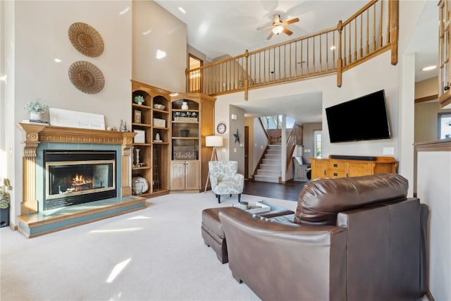 4199 Brookside Dr, Marion, IA 52302 - living room with stairs, a towering ceiling, carpet flooring, a ceiling fan, and a glass covered fireplace
