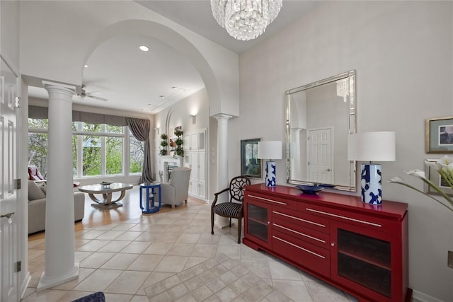 foyer entrance with a high ceiling, arched walkways, ornate columns, and light tile patterned floors