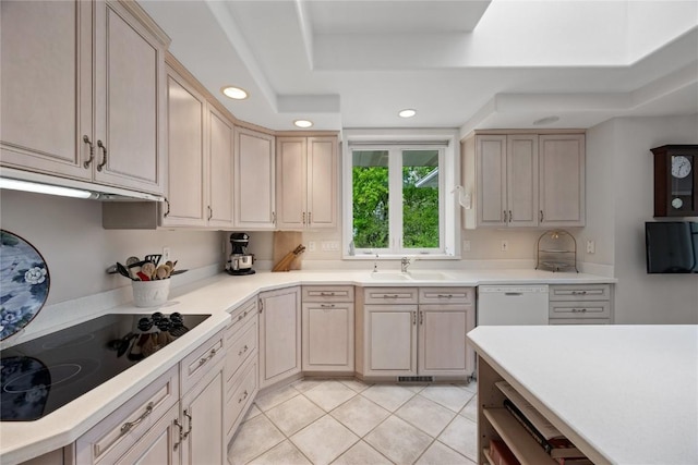 kitchen featuring a sink, black electric stovetop, recessed lighting, light tile patterned floors, and a tray ceiling
