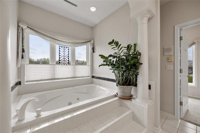 full bathroom featuring a jetted tub, a wealth of natural light, ornate columns, and visible vents
