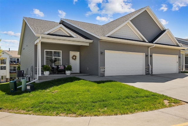view of front of house with an attached garage, concrete driveway, a front lawn, a porch, and roof with shingles