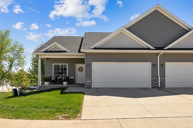 view of property with concrete driveway, a front yard, a garage, and stone siding