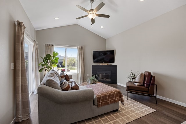 living room featuring a wealth of natural light, a glass covered fireplace, ceiling fan, and wood finished floors
