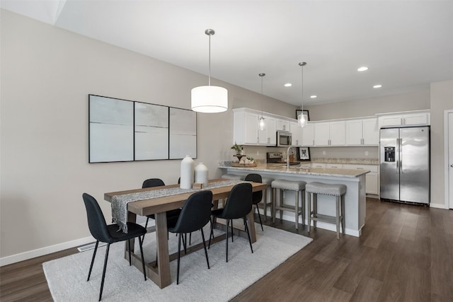 dining area with baseboards, dark wood-style flooring, and recessed lighting
