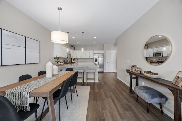 dining room with dark wood-style flooring, baseboards, and recessed lighting