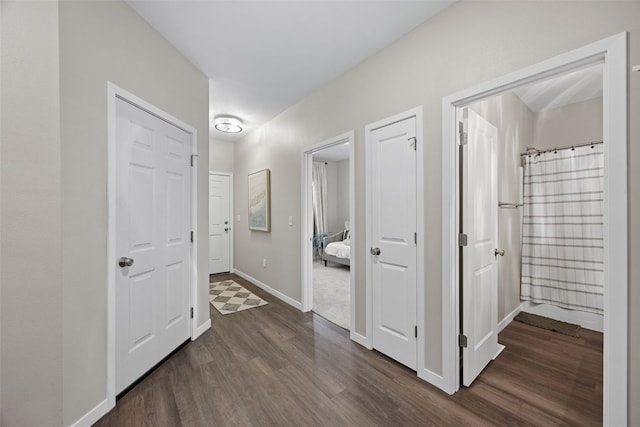 corridor with baseboards and dark wood finished floors
