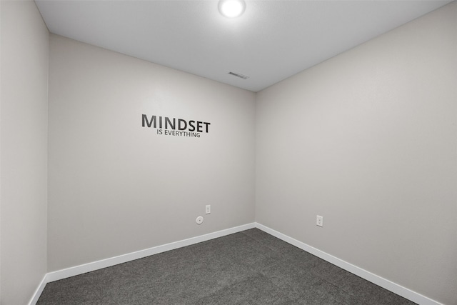 unfurnished room with baseboards, dark carpet, and visible vents
