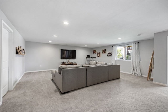 carpeted living area featuring baseboards, visible vents, and recessed lighting