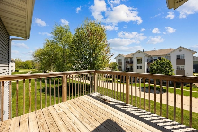 wooden terrace with a residential view and a lawn