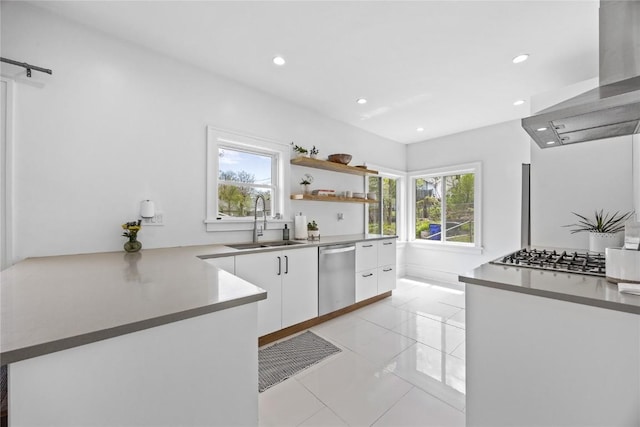 kitchen featuring a sink, stainless steel appliances, wall chimney range hood, recessed lighting, and white cabinets