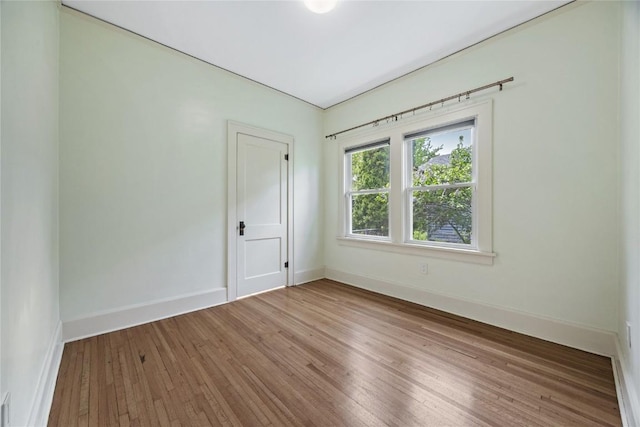 empty room with baseboards and hardwood / wood-style floors