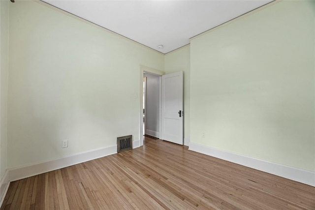 unfurnished room featuring visible vents, wood finished floors, and baseboards