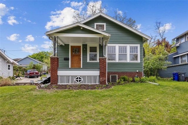 bungalow-style home featuring covered porch and a front yard