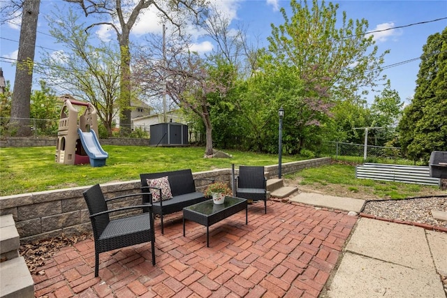 view of patio / terrace featuring an outdoor structure, a storage shed, an outdoor hangout area, a playground, and a fenced backyard