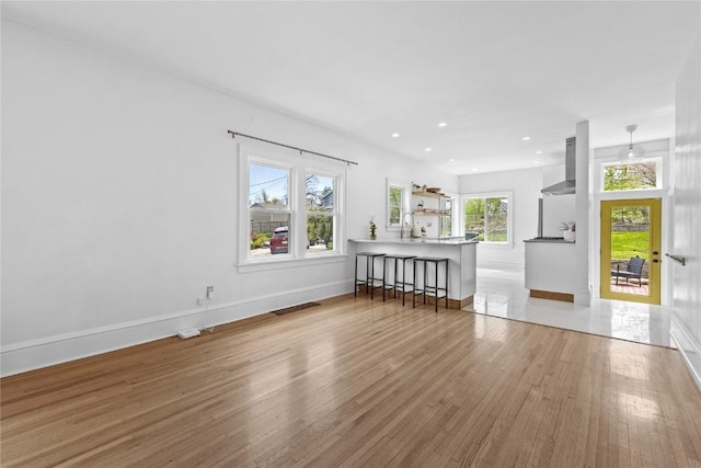 living room featuring recessed lighting, baseboards, and wood finished floors