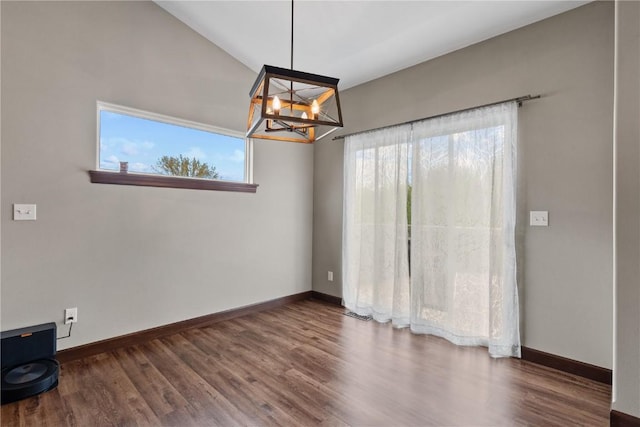 interior space with baseboards, an inviting chandelier, and wood finished floors