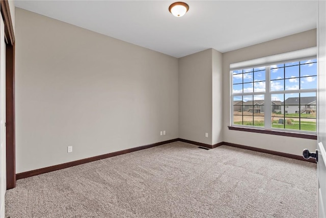 carpeted empty room with visible vents and baseboards
