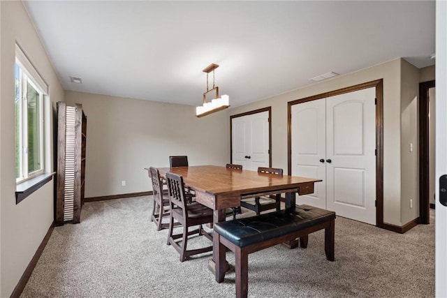 dining area with light colored carpet, visible vents, and baseboards