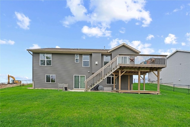 back of house featuring a lawn, fence, a wooden deck, and stairs