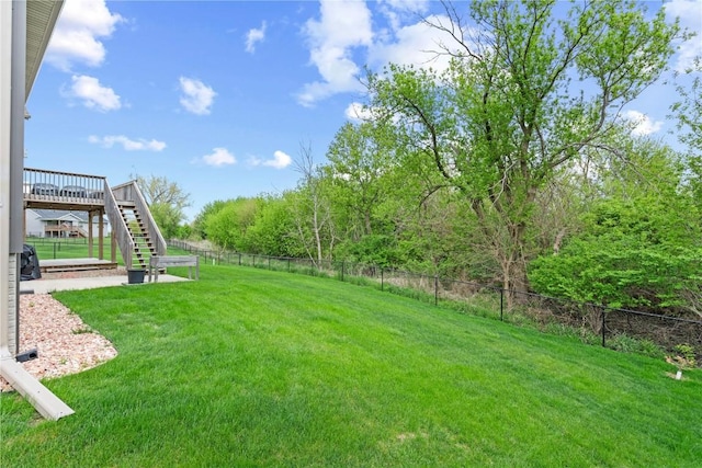 view of yard with stairs, a deck, and a fenced backyard