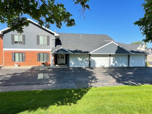tri-level home with driveway, brick siding, and a garage