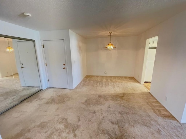 unfurnished room with a textured ceiling and carpet flooring