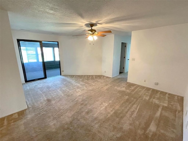 empty room with a ceiling fan, a textured ceiling, and light colored carpet