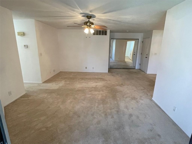 carpeted empty room featuring visible vents and a ceiling fan