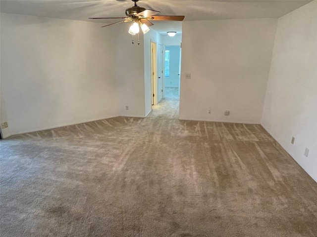 carpeted spare room featuring a ceiling fan