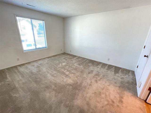unfurnished room featuring light carpet and a textured ceiling
