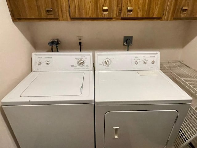 laundry area featuring separate washer and dryer and cabinet space