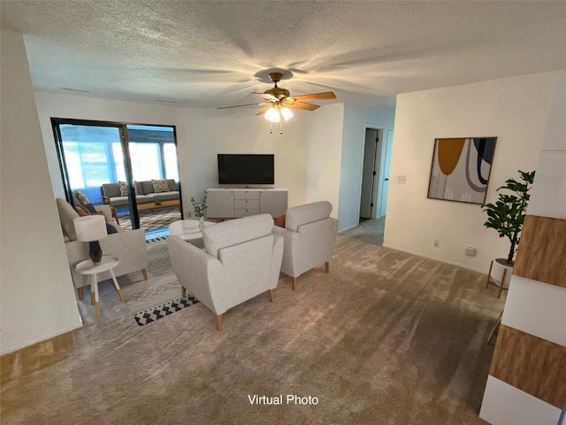 carpeted living room featuring ceiling fan and a textured ceiling
