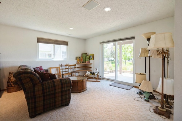 living area with carpet flooring, a textured ceiling, and recessed lighting