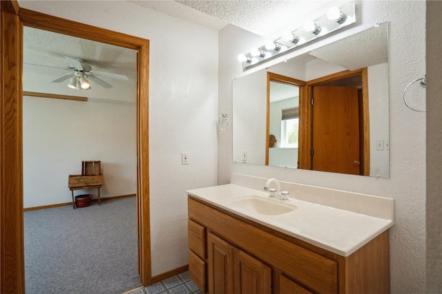 bathroom featuring vanity, ceiling fan, and a textured ceiling
