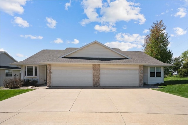 view of front facade featuring a front yard, a garage, brick siding, and driveway