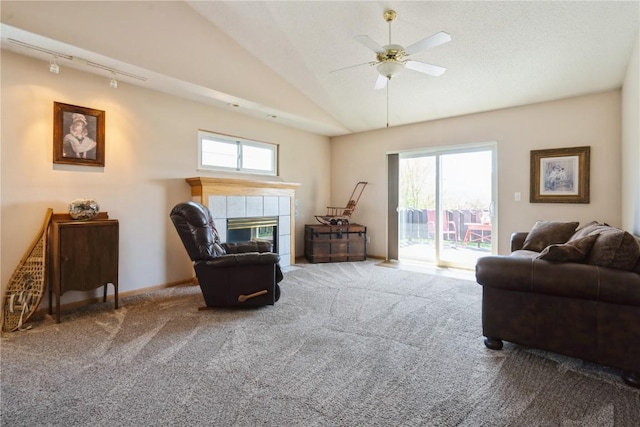 living area with a tile fireplace, a wealth of natural light, ceiling fan, and carpet floors