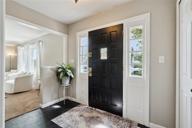 335 Parkland Dr SE, Cedar Rapids, IA 52403 - entrance foyer with crown molding, dark tile patterned flooring, dark colored carpet, and baseboards