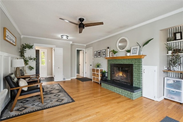 335 Parkland Dr SE, Cedar Rapids, IA 52403 - living room with crown molding, a brick fireplace, ceiling fan, and wood finished floors