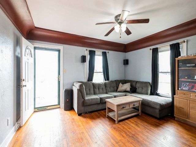 living room featuring a ceiling fan, light wood-style flooring, and healthy amount of natural light