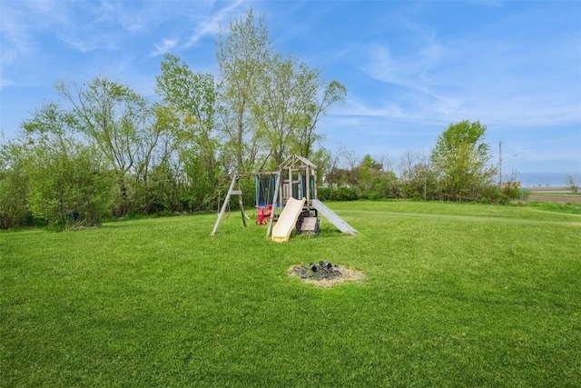 view of green lawn featuring a playground