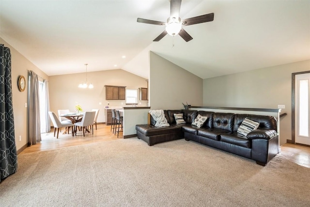 living area featuring light colored carpet, lofted ceiling, a ceiling fan, a chandelier, and baseboards